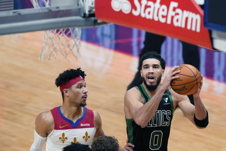 Boston Celtics forward Jayson Tatum (0) drives to the basket past New Orleans Pelicans guard Josh Hart to score the tying points in the second half of an NBA basketball game in New Orleans, Sunday, Feb. 21, 2021. (AP Photo/Gerald Herbert)