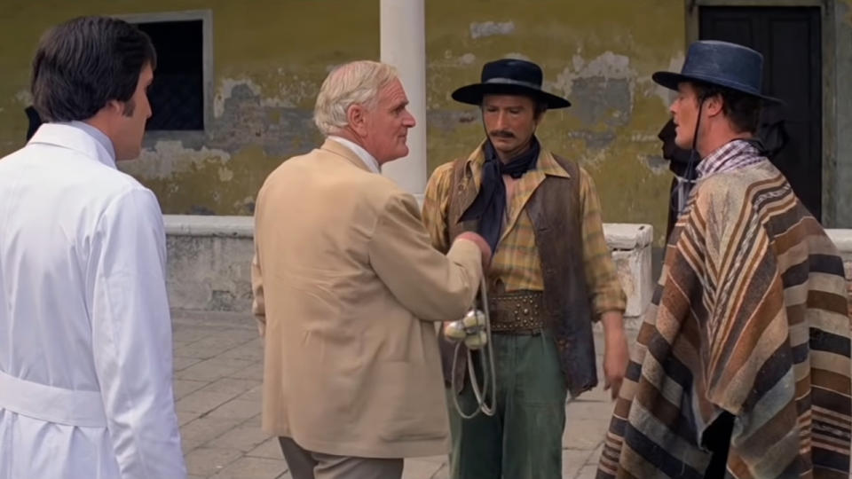 Desmond Llewelyn handing the explosive bolas to his assistant, as Roger Moore watches, in Moonraker.