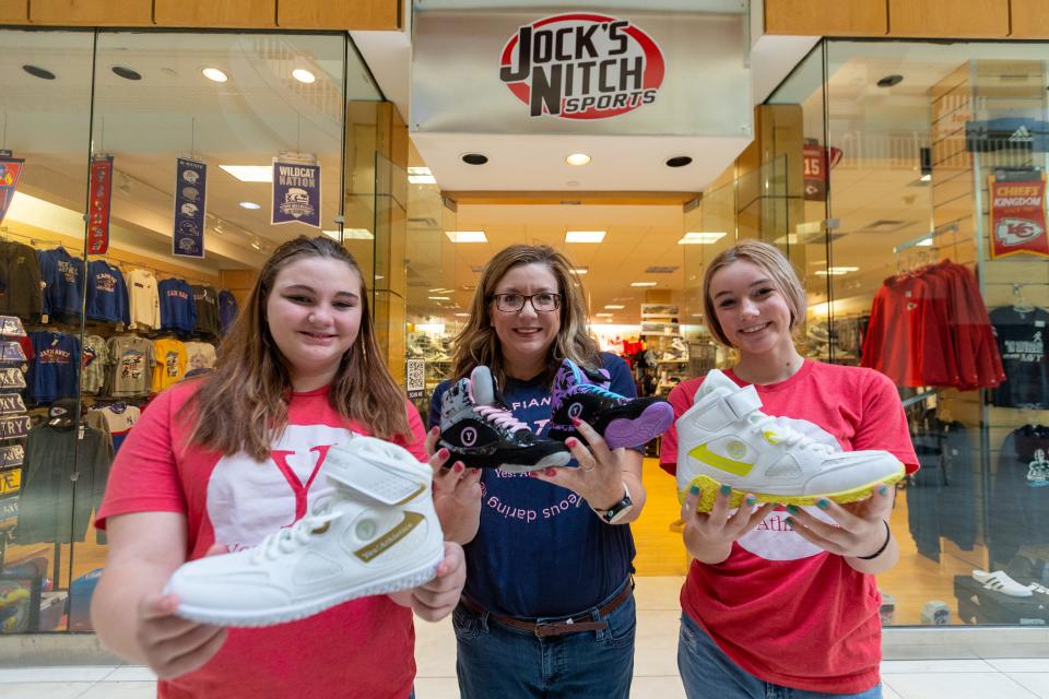 Yes! Athletics owner Deb North, middle, and her daughters Annie, seventh-grader at Landon Middle School, and Rae, sophomore at Hayden High School, on Sunday show off pairs of their women-specific wrestling shoes. The shoes are sold at Jock's Nitch at West Ridge Mall. North received the first-place prize of $15,000 through this year's Pitch Competition.