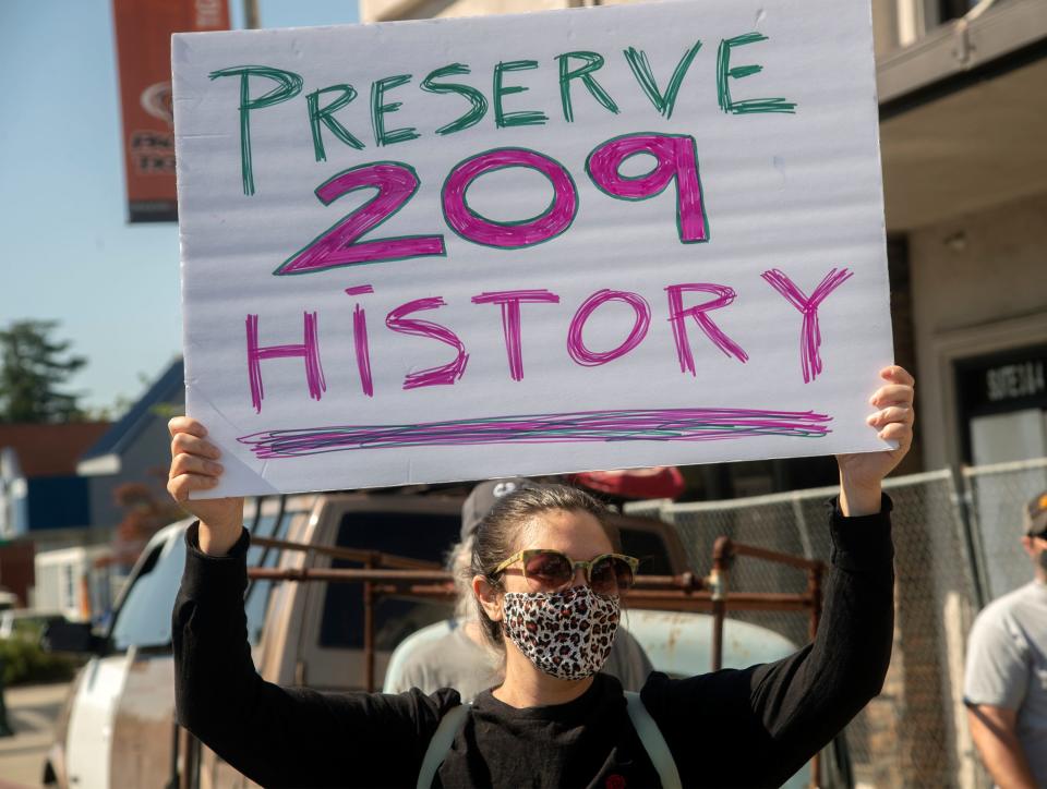 Natalie Abanavas holds up a sign at a rally to save the facade of the Empire Theatre on the Miracle Mile in Stockton. The theater was heavily damaged by a five-alarm fire on Friday. The group hopes to at least save the facade of the historic theater and preserve a portion of Stockton's cultural heritage. CLIFFORD OTO/THE STOCKTON RECORD