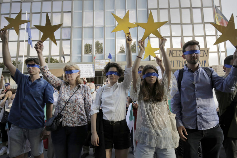 Protesters hold EU stars and keep their eyes closed in front of the German Embassy in Sofia, Bulgaria, Wednesday, Aug. 12, 2020. Several hundred anti-government protesters gathered in front of Germany’s embassy, calling on Berlin and Brussels to “open their eyes” to widespread corruption in Bulgaria. During the peaceful protest, dubbed “Eyes Wide Shut,” organizers complained that the European Union has willfully ignored the state of affairs in its poorest member state. (AP Photo/Valentina Petrova)