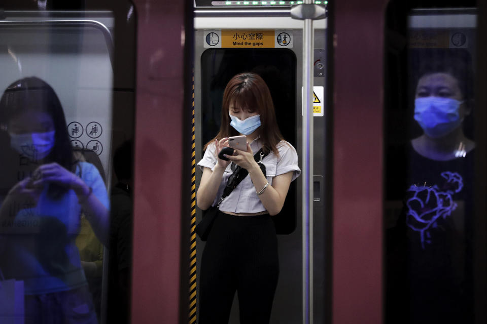 Commuters wearing face masks to protect against the new coronavirus ride in a subway train in Beijing, Wednesday, July 29, 2020. China reported more than 100 new cases of COVID-19 on Wednesday as the country continues to battle an outbreak in Xinjiang. (AP Photo/Andy Wong)