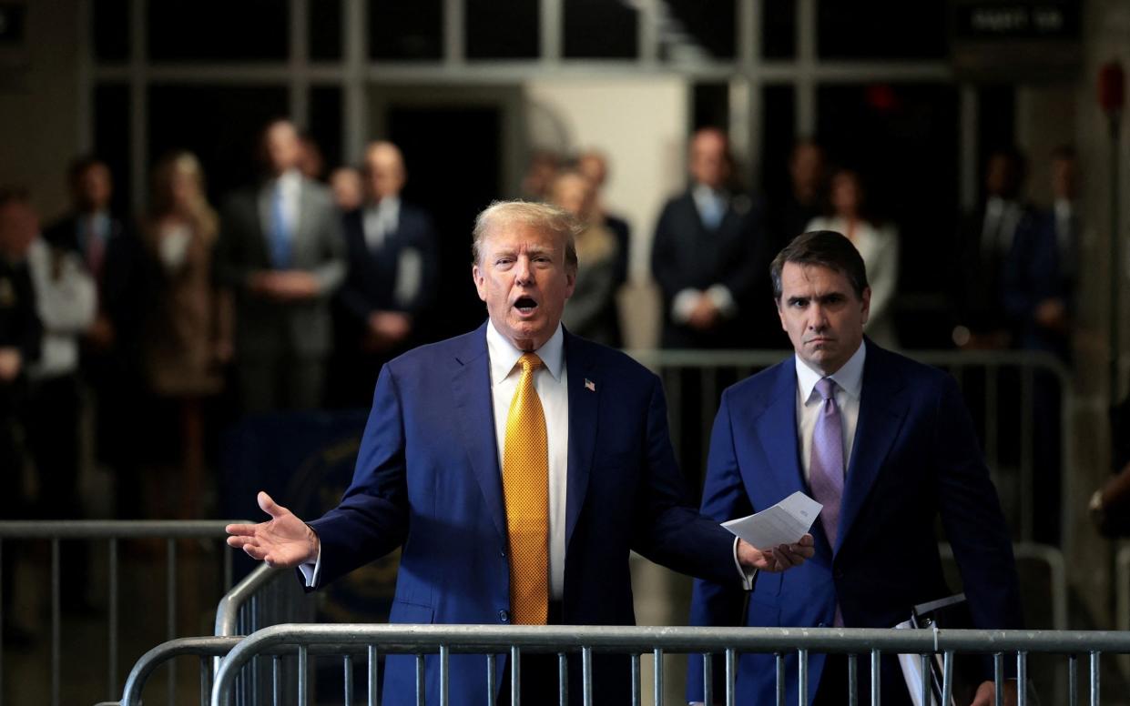 Donald Trump speaks to members of the media next to his lawyer Todd Blanche