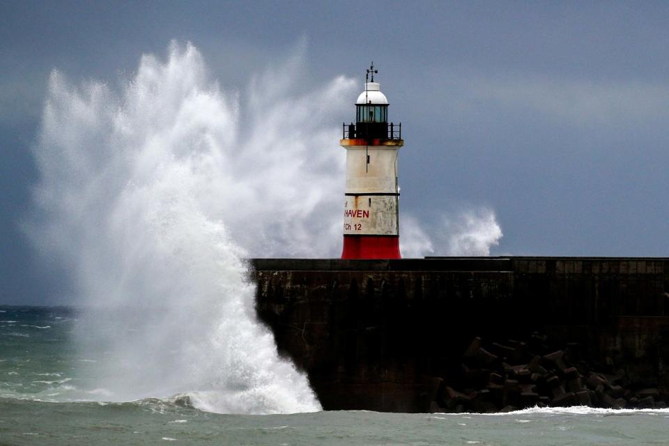 Waves crash against the harbour wall in Newhaven, Sussex on Wednesday (PA)