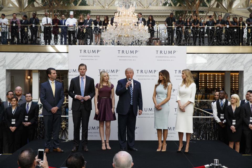 FILE - In this Oct. 26, 2016, file photo, Republican presidential candidate Donald Trump, accompanied by, from left, Donald Trump Jr., Eric Trump, Trump, Melania Trump, Tiffany Trump and Ivanka Trump, speaks during the grand opening of the Trump International Hotel- Old Post Office, in Washington. Trump had planned a news conference for Thursday on the future of his business but announced Monday, Dec. 12, he would postpone it until next month. (AP Photo/ Evan Vucci, File)