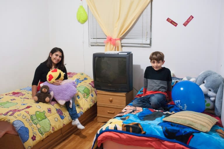 Sparta (L) and her brother Adeeb Fattouh, pose in the bedroom of their apartment in Laval, Canada