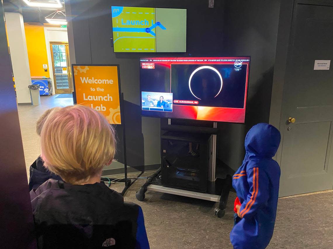 Children watch a live stream of an annular eclipse over New Mexico from the Morehead Planetarium and Science Center.