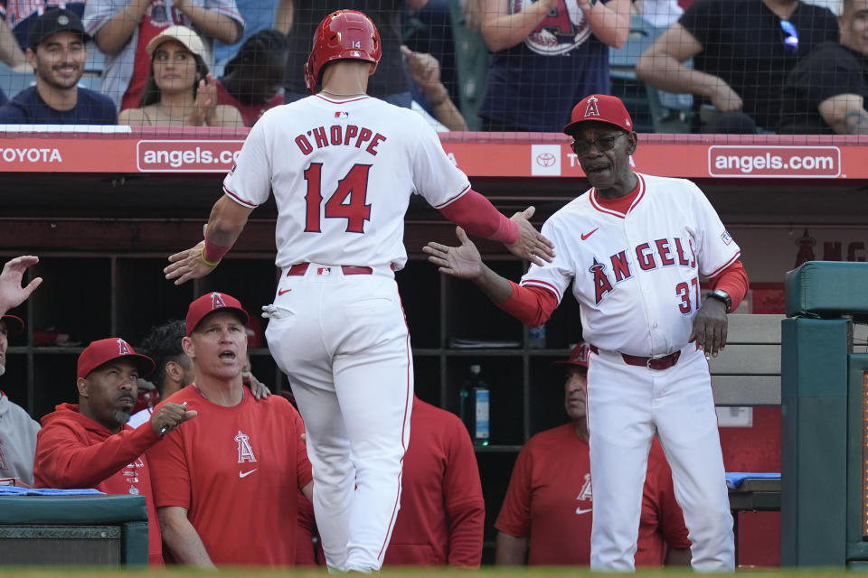 Los Angeles Angels' Logan O'Hoppe (14) celebrates with manager Ron Washington, right, after scoring off a two-run triple hit by Mickey Moniak during the second inning of a baseball game against the Texas Rangers, Monday, July 8, 2024, in Anaheim, Calif. (AP Photo/Ryan Sun)