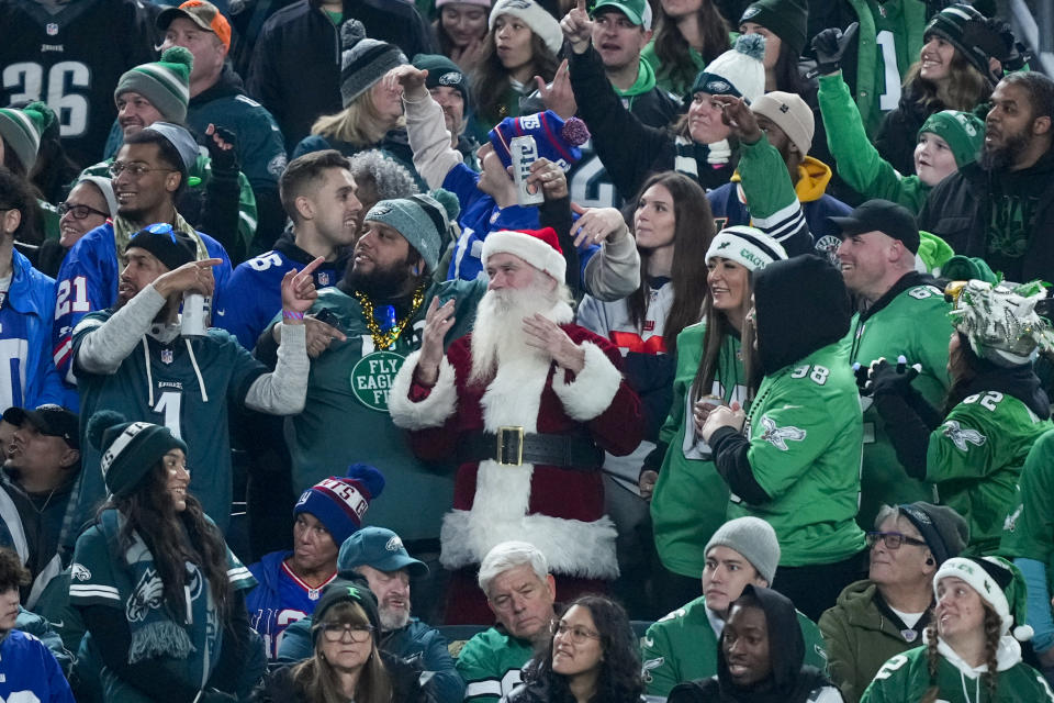 A fan dress like Santa Claus watches during the first half of an NFL football game between the Philadelphia Eagles and the New York Giants Monday, Dec. 25, 2023, in Philadelphia. (AP Photo/Matt Rourke)