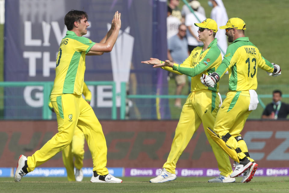Australia's Pat Cummins, left, is congratulated by teammate's Steve Smith and Matthew Wade, right, after taking the wicket of South Africa's Heinrich Klaasen during the Cricket Twenty20 World Cup match between South Africa and Australia in Abu Dhabi, UAE, Saturday, Oct. 23, 2021. (AP Photo/Kamran Jebreili )