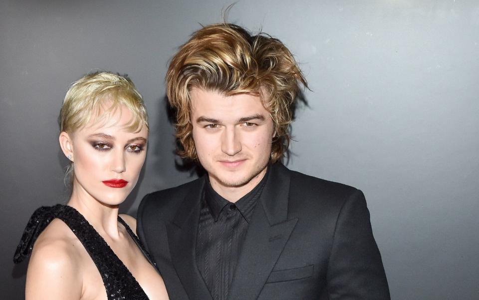 Maika Monroe and Joe Keery attend the Saint Laurent show at Paris Fashion Week. (Photo: Stephane Cardinale - Corbis via Getty Images)