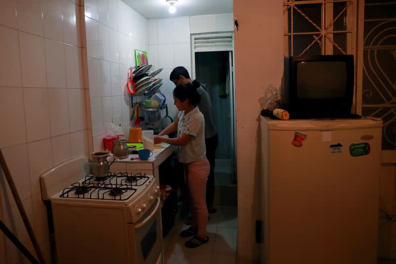 Diego Alvarez and his girlfriend Jetsymar Torres from Venezuela cook traditional Venezuelan breakfast at their house in Bogota