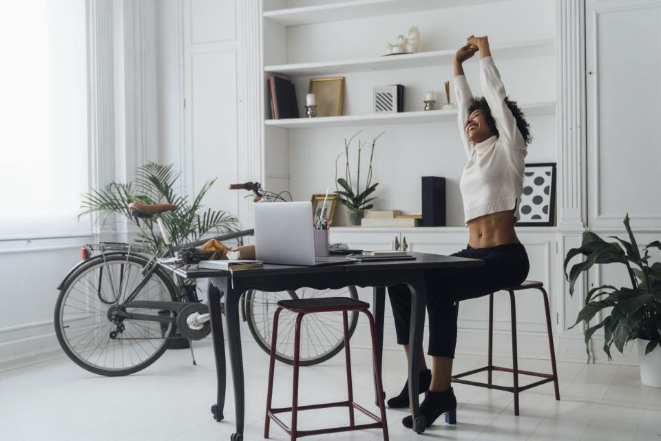 exercises-combat-desk-job-body , Mid adult woman sitting in her home office, smiling and stretching