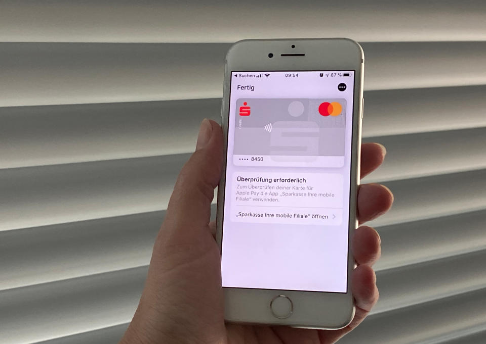 10 December 2019, Berlin: A customer of the Hamburger Sparkasse holds a mobile phone in her hand and adds her credit card to the Apple Pay payment service. On Tuesday, 371 savings banks in Germany, Commerzbank, Norisbank and LBBW, launched support for Apple's payment service. Photo: Christoph Dernbach/dpa (Photo by Christoph Dernbach/picture alliance via Getty Images)