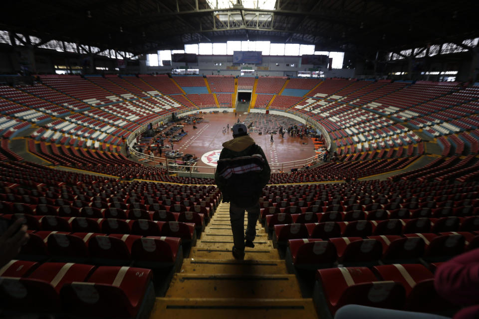 In this Nov. 12, 2018 photo, a Central American migrant, part of the caravan hoping to reach the U.S. border, arrives at the Benito Juarez Auditorium that is being as a migrant shelter, in Guadalajara, Mexico. Several thousand Central American migrants marked a month on the road Monday as they hitched rides toward the western Mexico city of Guadalajara. (AP Photo/Marco Ugarte)