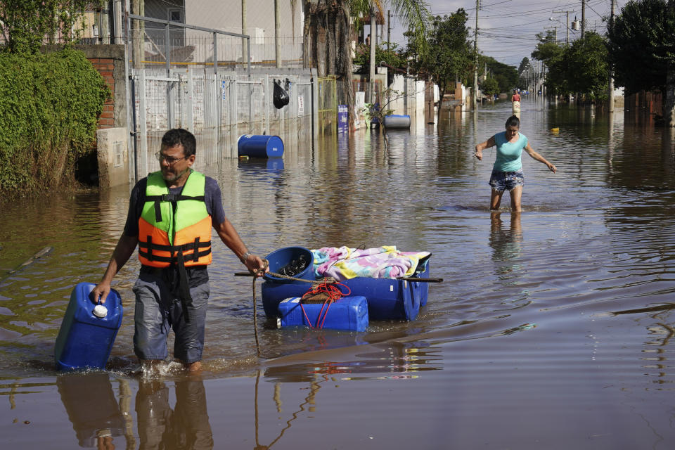 A resident pulls belongings he recovered from his flooded home after heavy rain in Canoas, Rio Grande do Sul state, Brazil, Thursday, May 9, 2024. (AP Photo/Carlos Macedo)