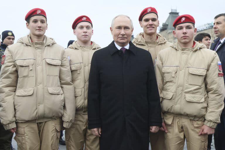 El presidente ruso, Vladimir Putin, posa para una foto con miembros del Movimiento Nacional de Jóvenes Cadetes del Ejército de Rusia e hijos de héroes caídos en la operación militar en Ucrania, después de la ceremonia de colocación de flores en la Plaza Roja de Moscú, durante el Día de la Unidad Nacional, el 4 de noviembre de 2023.