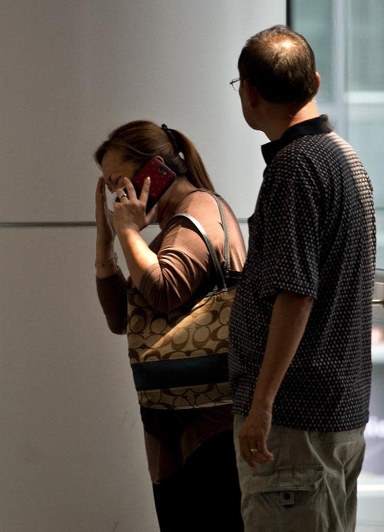 A woman talks on phone at a reception centre for families and friends after an airliner went missing at the Kuala Lumpur International Airport on March 8, 2014