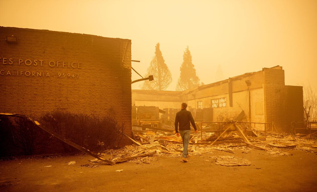 California Governor Gavin Newsom surveys a burned United States Post Office in downtown Greenville, Calif. on Aug. 7, 2021. The Dixie Fire has now ravaged 446,723 acres in four counties, up from the previous day's 434,813. That area is larger than Los Angeles and has surpassed the sweep of the vast Bootleg Fire in southern Oregon.