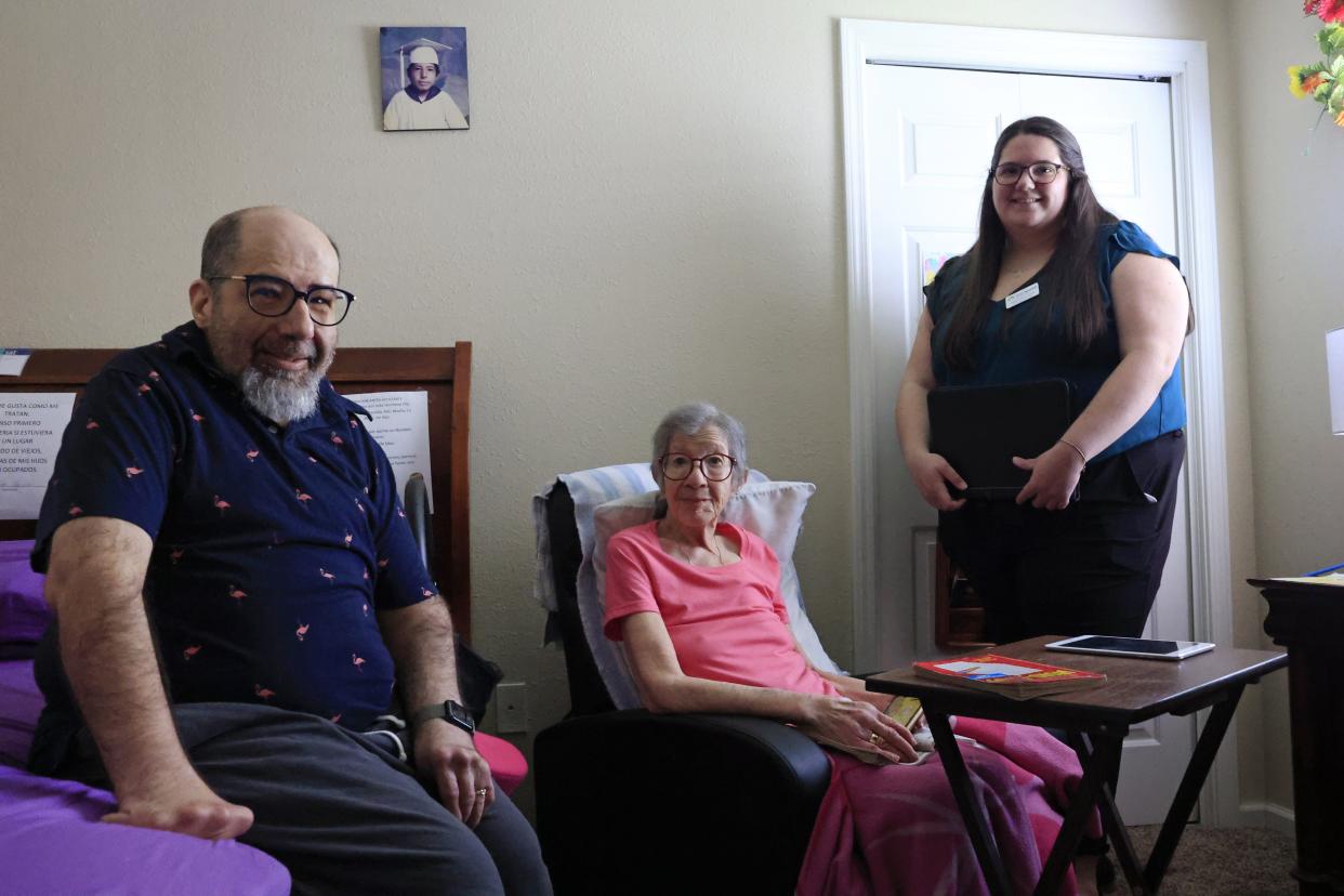 Hector De Jesus, his mother Alba De Jesus and their social worker Abigail Costley, direct programs manager for ElderSource, pose at the family home. ElderSource has connected the family with multiple services, including a new online caregiving program in their native language, Spanish.