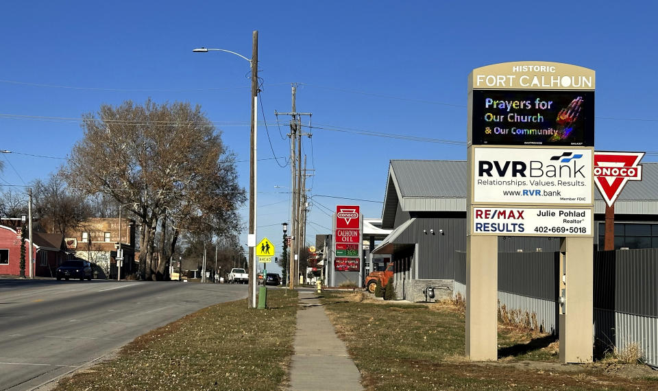 A sign greeting visitors to Fort Calhoun, Neb., asks for "Prayers for Our Church & Our Community," Monday, Dec. 11, 2023, one day after a Catholic priest was fatally stabbed in the rectory where he lived next to the church he served. (AP Photo/Josh Funk)