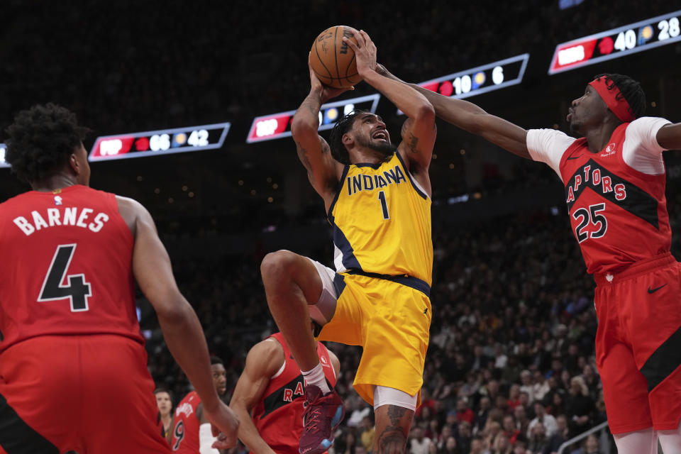 Indiana Pacers' Obi Toppin shoots on Toronto Raptors' Chris Boucher, right, as Scottie Barnes looks on during the second half of an NBA basketball game Wednesday, Feb. 14, 2024, in Toronto. (Chris Young/The Canadian Press via AP)