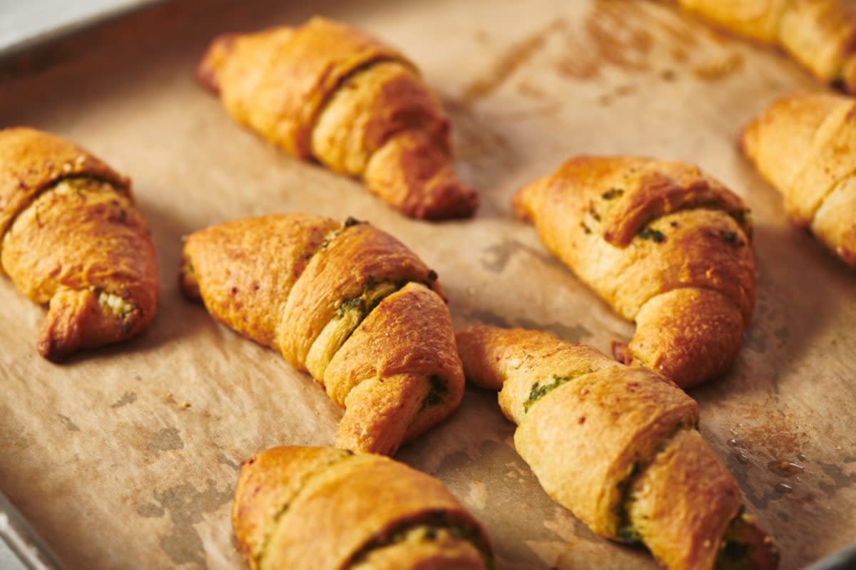 <p>Katie Workman</p><p>With a quick brush of pesto and a sprinkle of cheese refrigerated crescent rolls become something extra special. Rollin up the crescent rolls is a good kid activity.</p><p><strong>Get the recipe: <a href="https://themom100.com/recipe/pesto-crescent-rolls/" rel="nofollow noopener" target="_blank" data-ylk="slk:Pesto Crescent Rolls;elm:context_link;itc:0;sec:content-canvas" class="link rapid-noclick-resp">Pesto Crescent Rolls</a></strong></p>