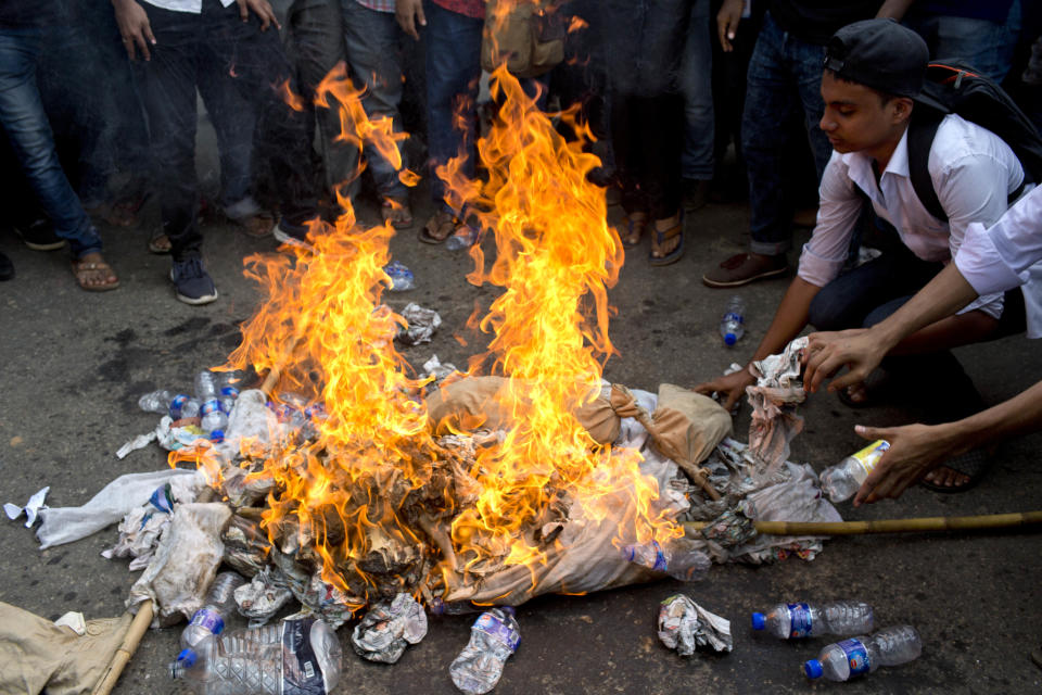 Bangladeshi students burn an effigy of Bangladesh's Shipping Minister Shahjahan Khan, who is also a transport workers' leader, as they block a road during a protest in Dhaka, Bangladesh, Wednesday, Aug. 1, 2018. Students blocked several main streets in the capital, protesting the death of two college students in a bus accident in Dhaka. (AP Photo/A. M. Ahad)