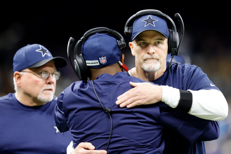 Dallas Cowboys acting head coach Dan Quinn embraces a fellow coach during the first half of a game vs. the Saints.