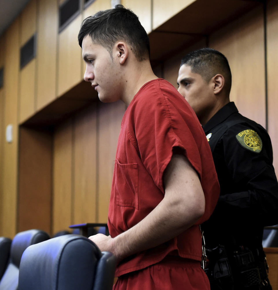 FILE- In this May 20, 2019, file photo, Wilber Ernesto Martinez-Guzman is escorted into the Washoe District Court room in Reno, Nev. Lawyers for the Salvadoran immigrant accused of killing four Nevadans are asking the state Supreme Court to overturn a judge's ruling upholding a grand jury's authority to indict him in Reno for two of the fatal shootings outside the county. Public defenders for Martinez Guzman want the high court to dismiss two counts each of murder with a deadly weapon and burglary in the January deaths of Connie Koontz and Sophia Renken in Douglas County south of Carson City. (Andy Barron/Reno Gazette-Journal via AP, Pool, File)