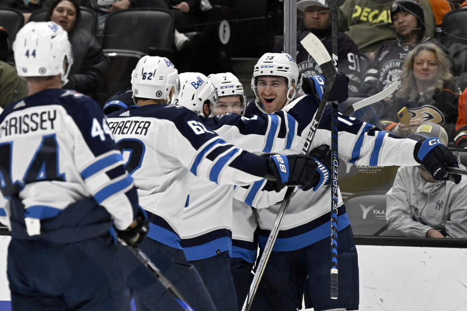 Winnipeg Jets center Gabriel Vilardi, right, celebrates with teammates after scoring against the Anaheim Ducks during the third period of an NHL hockey game in Anaheim, Calif., Sunday, Dec. 10, 2023. (AP Photo/Alex Gallardo)