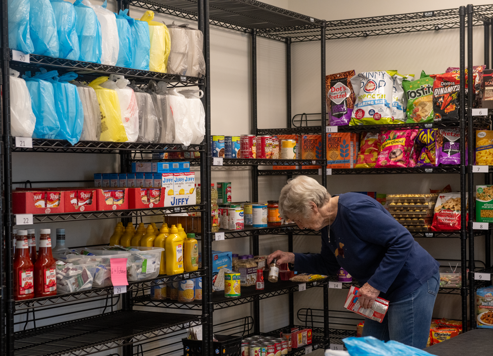 Suffield-Atwater-Randolph Food Shelf director Joan Trautman arranges a shelf at the food bank on Waterloo road in Suffield.