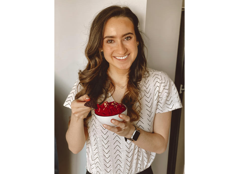 Caroline Hoffman, 25, holding her homemade beet hummus in Chicago on Jan. 23, 2021. Beets never got a chance from Hoffman, until the pandemic arrived and she forgot to buy tomatoes for pizza sauce one day and blended up some beets instead. She has made beet hummus, beet pasta and beet salads since then. (Nathan Fleischer via AP)