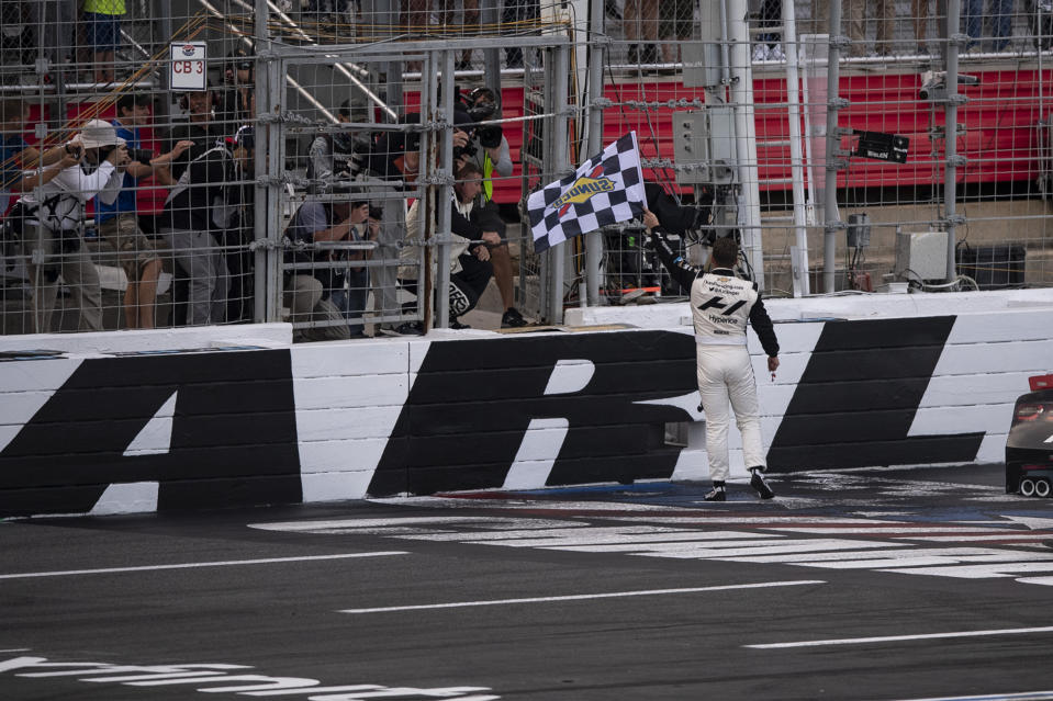 NASCAR Xfinity Series driver AJ Allmendinger (16) celebrates out of his car with the checkered flag after winning the NASCAR Xfinity auto racing race at the Charlotte Motor Speedway Saturday, Oct. 9, 2021, in Concord, N.C. (AP Photo/Matt Kelley)