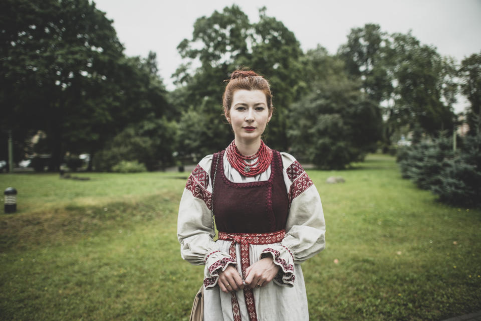 Olga Baryshnikova, 24, a student and a singer in a choir poses for a photo wearing Belarusian national costume in Minsk, Belarus, Wednesday, Aug. 19, 2020. She said she can't sit silent at a time like this. "I hurt for Belarus," she said, tears in her eyes. (AP Photo/Evgeniy Maloletka)