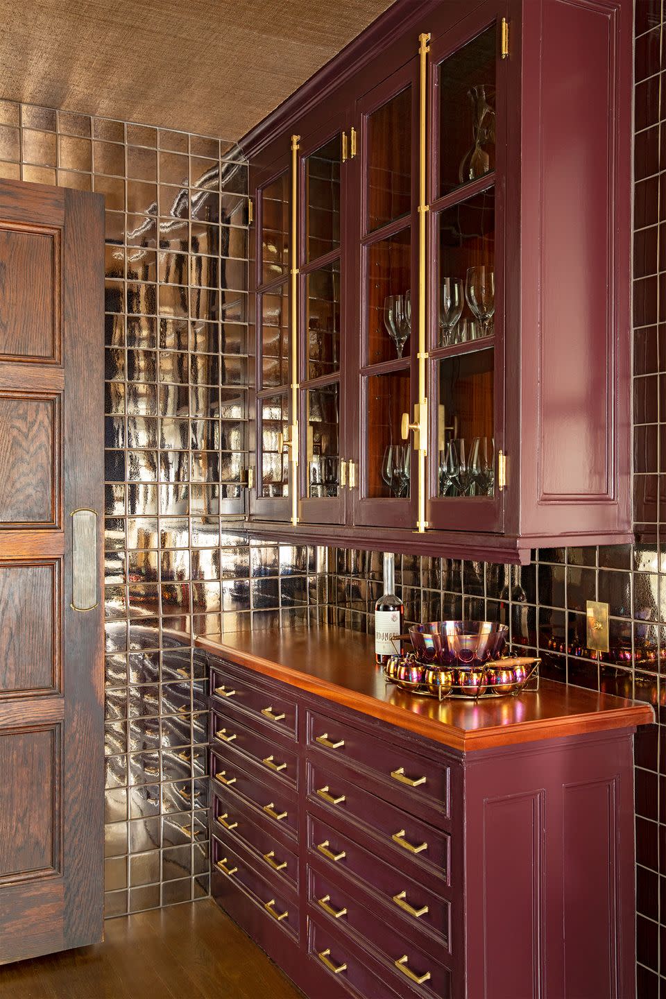 <p>Paint the cabinets a red wine-inspired hue in an adjacent butler's pantry or entertaining space to set the mood for a tasting. We're digging the smokey mirrored tiles in this space by <a href="https://birgittepearcedesign.com/" rel="nofollow noopener" target="_blank" data-ylk="slk:Birgitte Pearce Design;elm:context_link;itc:0;sec:content-canvas" class="link ">Birgitte Pearce Design</a>—they elevate the entire experience. </p>