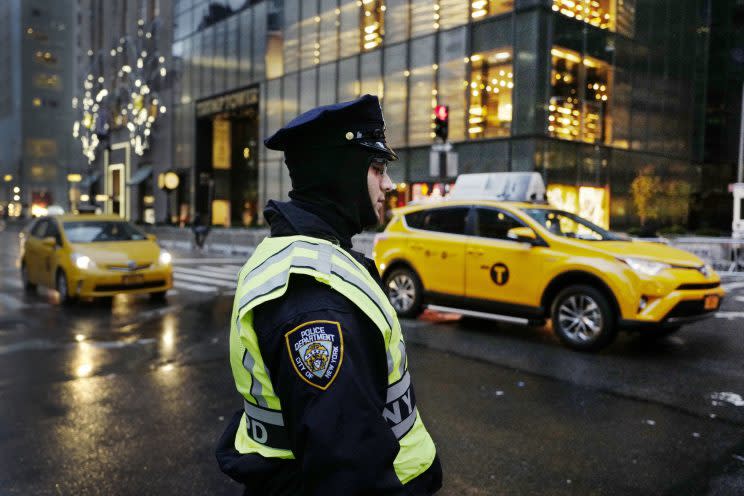 A New York City police officer stands watch outside Trump Tower, December 2016. (Photo: Mark Lennihan/AP)