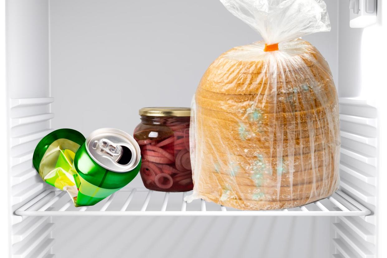 A fridge with moldy bread and a crushed-up can in it. 