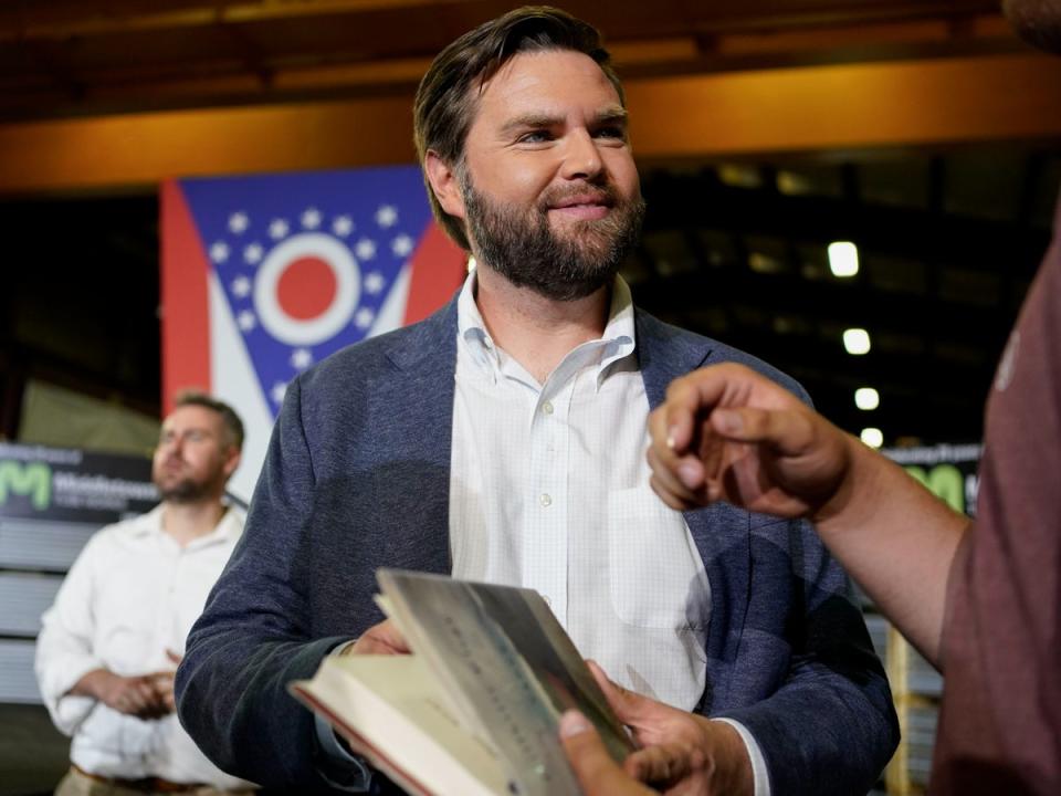 Vance holds a copy of his book ‘Hillbilly Elegy’ as he meets voters in his hometown after announcing his 2022 Senate run (AP Photo/Jeff Dean)