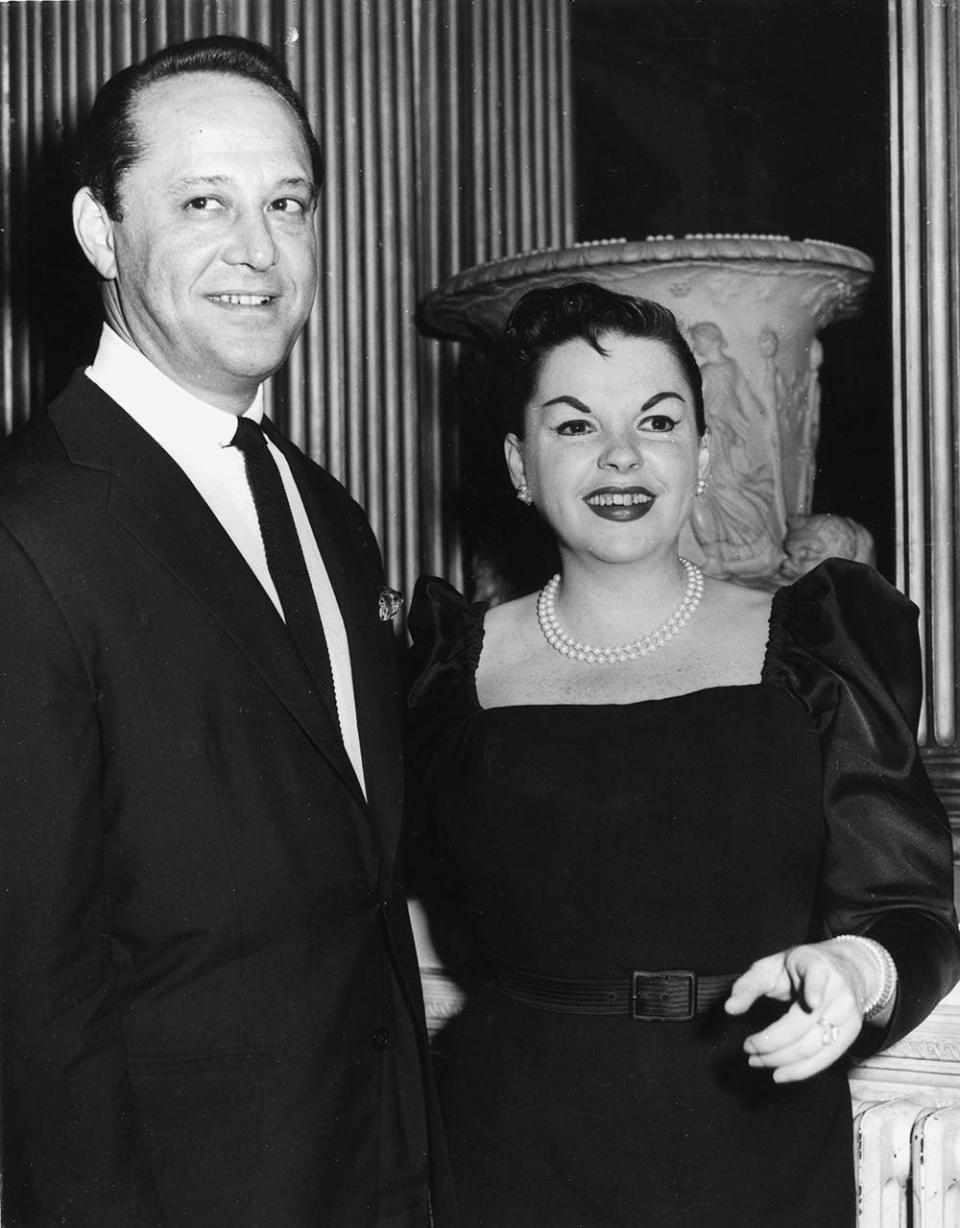 Sid Luft smiling next to Judy Garland in a black dress