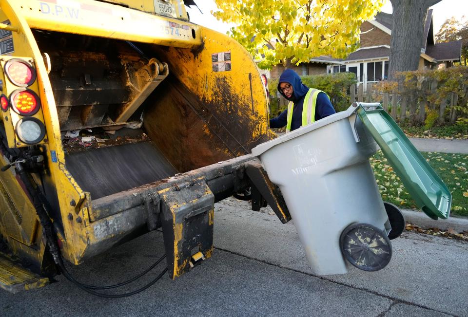 Amir Collins a Milwaukee Department of Public Works city laborer collects garbage on North 54th Street north of West Garfield Avenue in Milwaukee on Monday, Oct. 30, 2023.