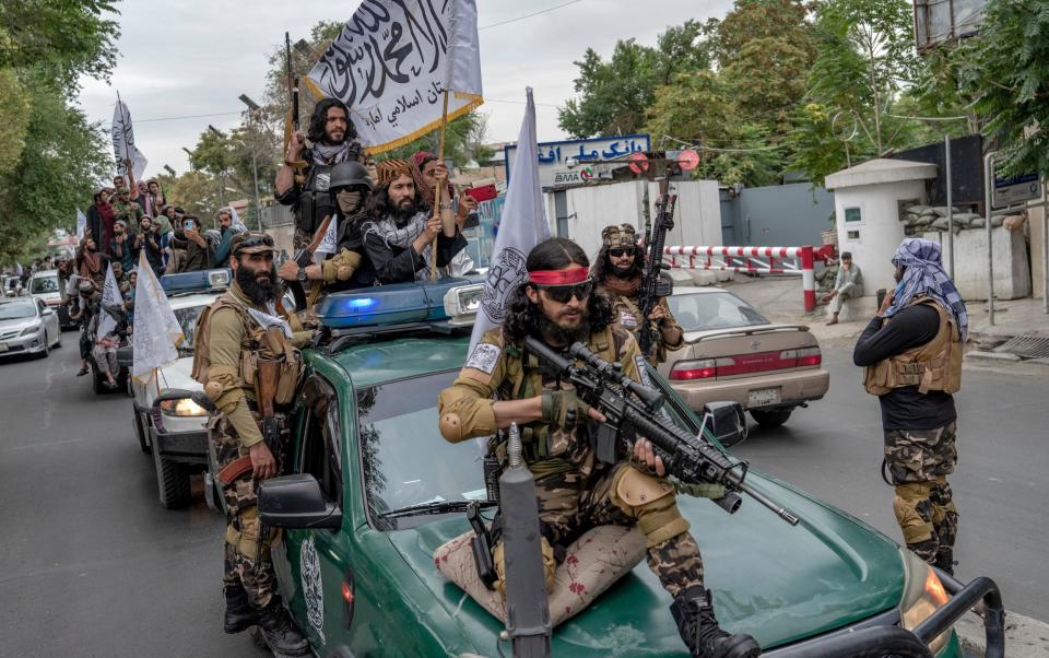 Taliban fighters celebrate one year since taking Kabul, as they held up rifles and chanted slogans - Ebrahim Noroozi/AP Photo 