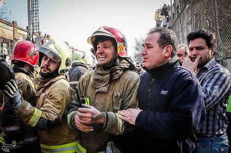 A firefighter reacts at the site of a collapsed high-rise building in Tehran, Iran January 19, 2017. Tasnim News Agency/Handout via REUTERS