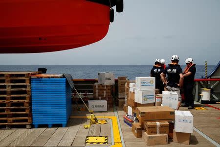Crew members on the Migrant Offshore Aid Station (MOAS) ship Topaz Responder wait to transfer supplies to the MOAS ship Phoenix in international waters off the coast of Libya, June 18, 2016. REUTERS/Darrin Zammit