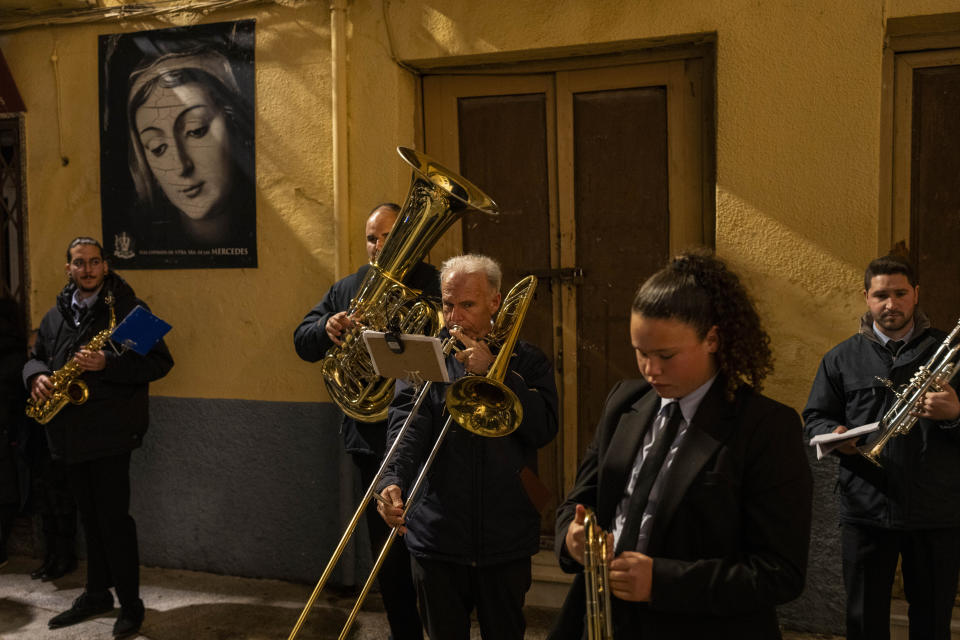 Members of a music band warm up prior performing during a Holy Week procession in the southern city of Alcala la Real, Spain, Thursday, March 28, 2024. (AP Photo/Bernat Armangue)