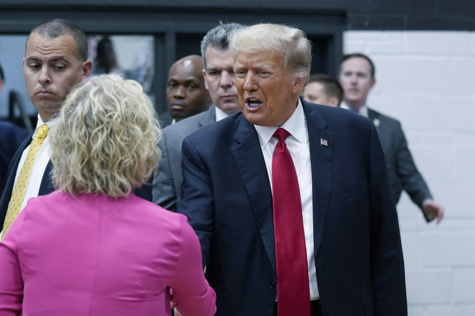 Former President Donald Trump, right, visits with campaign volunteers at the Grimes Community Complex Park, Thursday, June 1, 2023, in Des Moines, Iowa. (AP Photo/Charlie Neibergall)