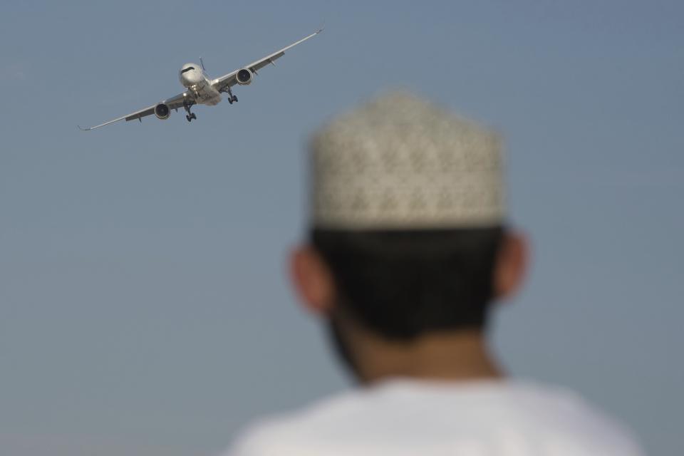 A man watches an Airbus A350 at the Dubai Air Show in Dubai, United Arab Emirates, Monday, Nov. 13, 2023. Long-haul carrier Emirates opened the Dubai Air Show with a $52 billion purchase of Boeing Co. aircraft, showing how aviation has bounced back after the groundings of the coronavirus pandemic, even as Israel's war with Hamas clouds regional security. (AP Photo/Jon Gambrell)