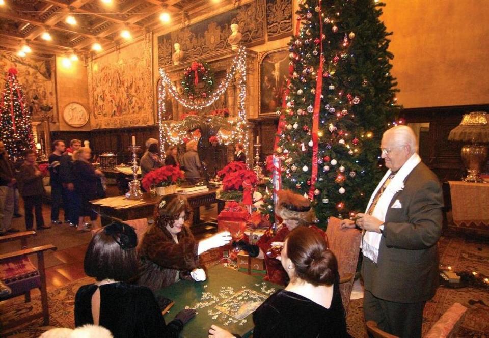Hearst Castle docents in costume work on a puzzle amid holiday decorations in the Assembly Room in 2015. The night tours including docent reenactments will not be offered this year.