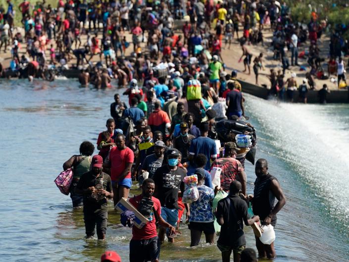 Haitian migrants use a dam to cross to and from the United States from Mexico, Friday, Sept. 17, 2021, in Del Rio, Texas.