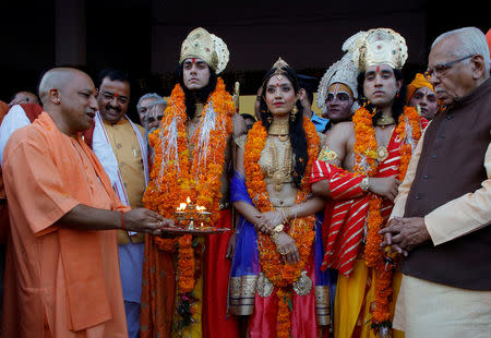 Yogi Adityanath (L), chief minister of Uttar Pradesh, welcomes artists dressed as the Hindu deity Ram, his wife Sita and his brother Laxman during Diwali celebrations in Ayodhya, October 18, 2017. REUTERS/Pawan Kumar/Files